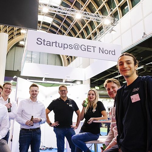 Personen am "startups@GET Nord" Stand blicken in die Kamera