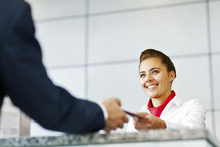 Hamburg Messe Besucherservice Service angestellte nimmt Dokumente eines Besuchers entgegen