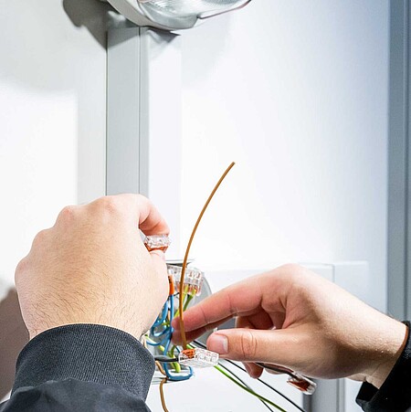Ein Elektriker arbeitet an kleinen Kabeln