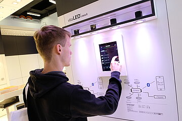 Ein Mann testet ein smartes LED System auf der Hamburg Messe und Congress.