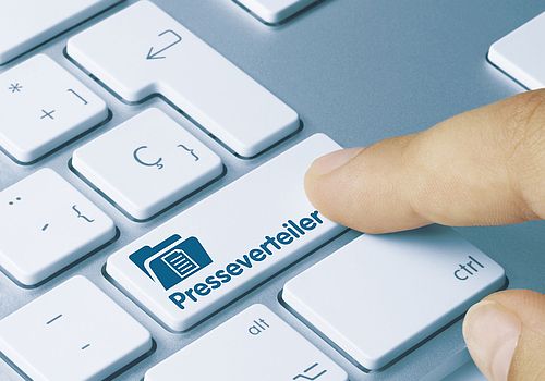 Computertastatur mit Taste "Presseverteiler", Finger klickt 
